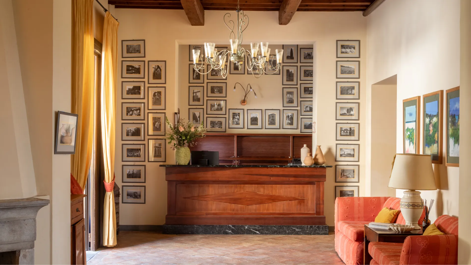Reception area at Villa San Filippo with wooden desk, photo gallery walls and rustic Tuscan interiors in Barberino Tavarnelle - Villa San Filippo, BZAR hotels in Tuscany