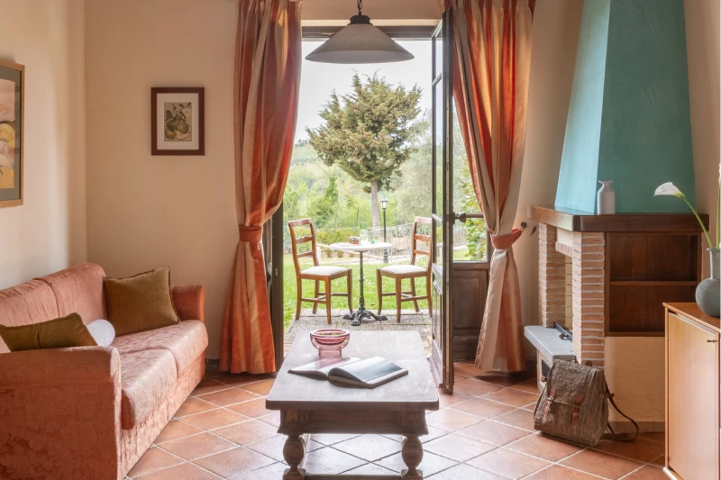 Family room with living area, sofa and French door opening to garden and Chianti hills in Barberino Tavarnelle - Villa San Filippo, BZAR hotels in Tuscany