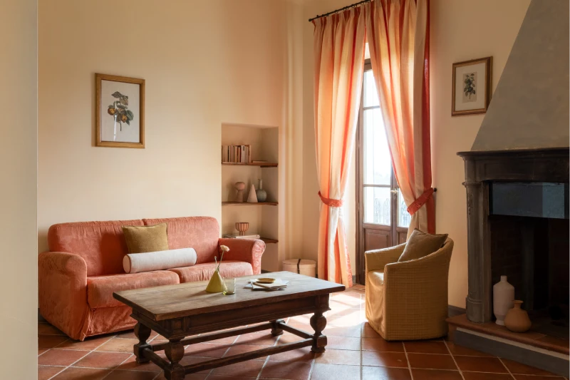 Bright living room with fireplace, sofa and views of the Chianti countryside, ideal for an exclusive stay in Tuscany - Villa San Filippo, BZAR hotels in Tuscany
