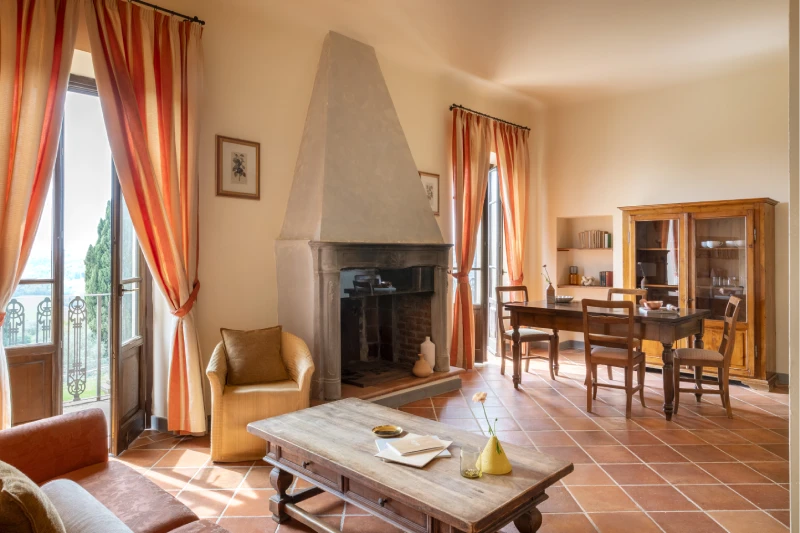 Spacious living area with traditional fireplace, dining space and natural light overlooking the Tuscan Chianti landscape - Villa San Filippo, BZAR hotels in Tuscany