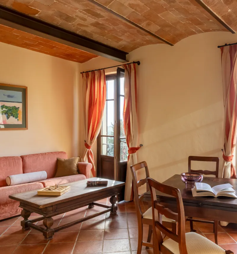 Suite with living area, sofa and dining table overlooking Chianti hills in Barberino Tavarnelle - Villa San Filippo, BZAR hotels in Tuscany
