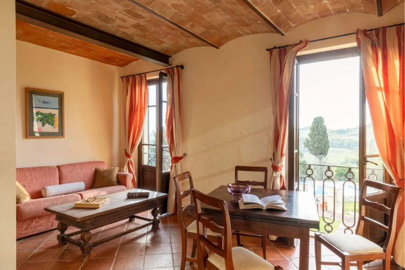 Suite with living area, sofa and dining table overlooking Chianti hills in Barberino Tavarnelle - Villa San Filippo, BZAR hotels in Tuscany