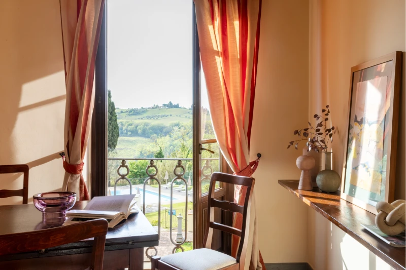 Suite with panoramic balcony and desk overlooking pool and Tuscan landscape in Barberino Tavarnelle - Villa San Filippo, BZAR hotels in Tuscany